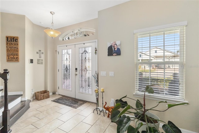 foyer with french doors, stairway, and baseboards