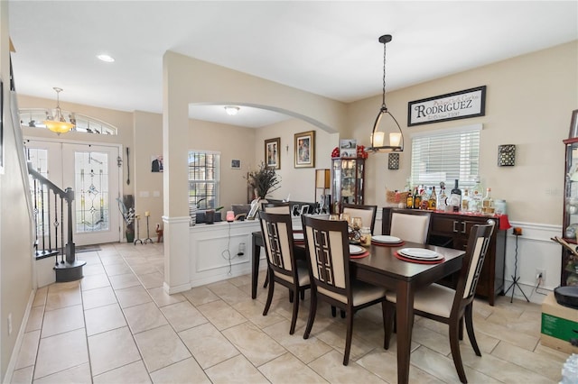 dining space with light tile patterned floors and arched walkways