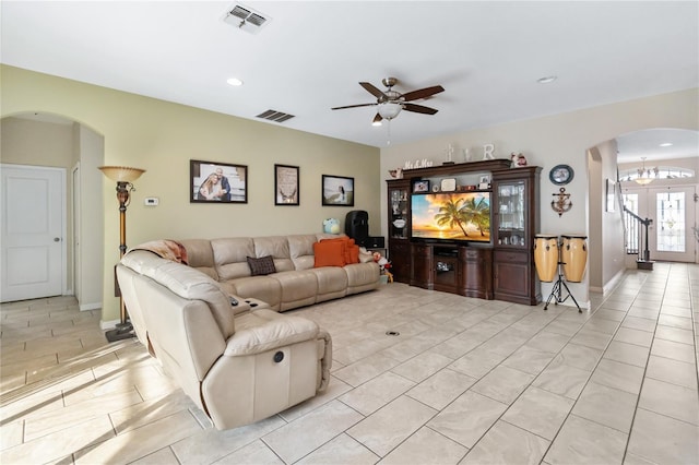 living room with arched walkways, visible vents, recessed lighting, and light tile patterned floors