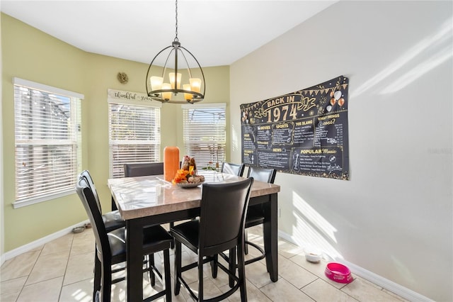 dining area featuring light tile patterned floors, baseboards, and an inviting chandelier