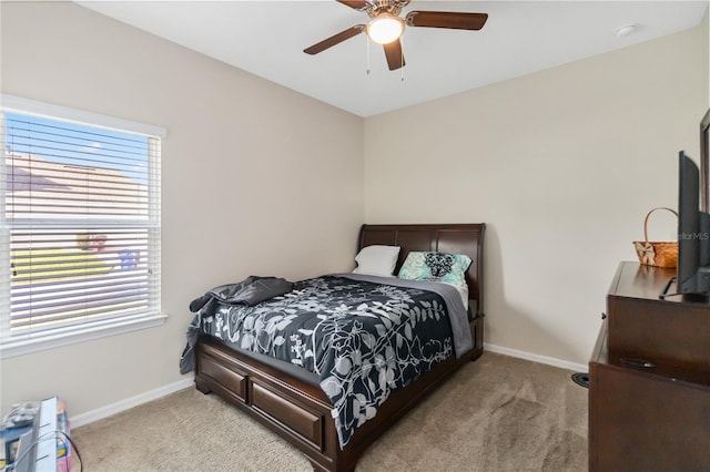 bedroom featuring light carpet, ceiling fan, and baseboards