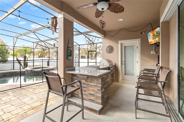 view of patio / terrace with ceiling fan, an outdoor kitchen, a lanai, outdoor wet bar, and area for grilling