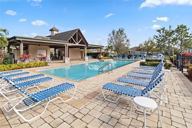 community pool featuring ceiling fan, a patio area, and fence