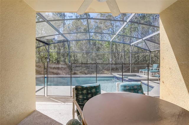 view of pool featuring glass enclosure, a patio area, a pool with connected hot tub, and outdoor dining area