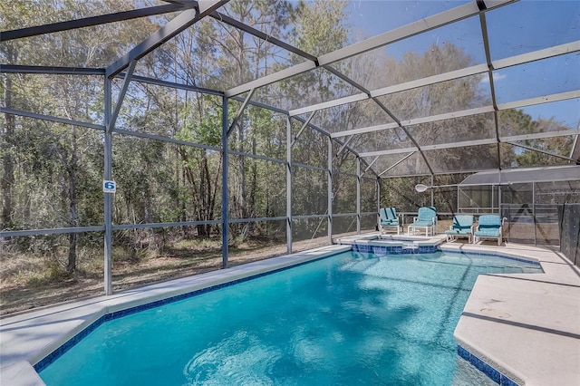 view of swimming pool featuring a patio area, a pool with connected hot tub, and glass enclosure