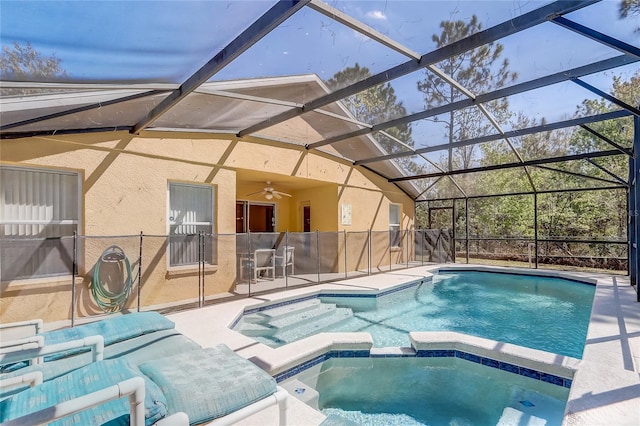 view of pool with a pool with connected hot tub, a patio area, ceiling fan, and a lanai