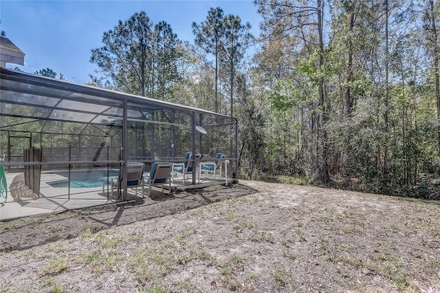 view of yard with a patio area, glass enclosure, and an outdoor pool