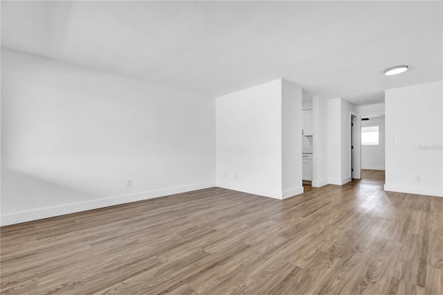 spare room featuring baseboards and wood finished floors