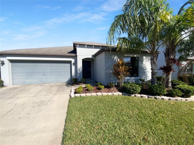 view of front of home featuring driveway, a garage, a front lawn, and stucco siding