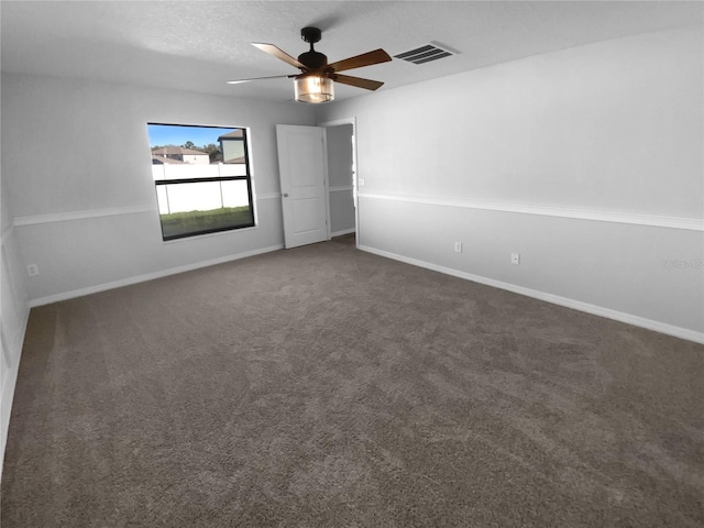 unfurnished bedroom with ceiling fan, baseboards, visible vents, and dark carpet