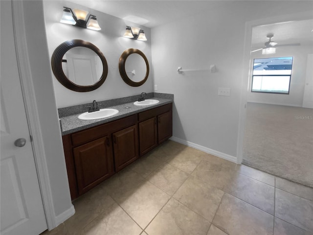 bathroom featuring double vanity, tile patterned floors, a sink, and baseboards