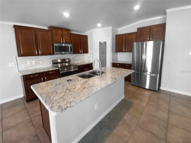 kitchen with an island with sink, appliances with stainless steel finishes, a sink, backsplash, and recessed lighting