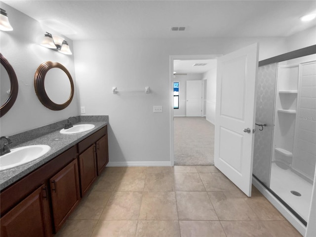 bathroom with a shower stall, visible vents, a sink, and tile patterned floors