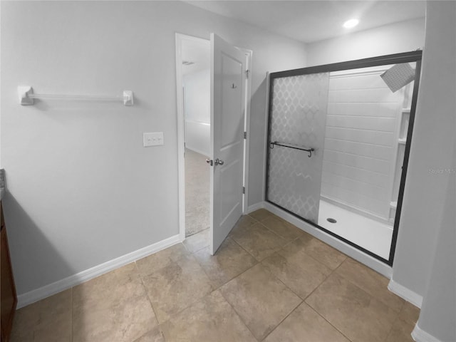 bathroom with a shower stall and baseboards