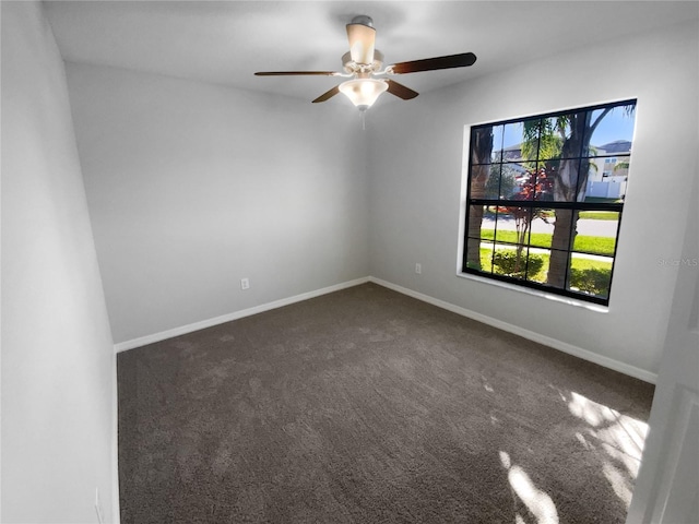 unfurnished room featuring ceiling fan, baseboards, and dark carpet