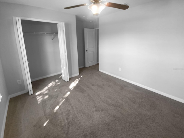 unfurnished bedroom featuring ceiling fan, baseboards, dark colored carpet, and a closet