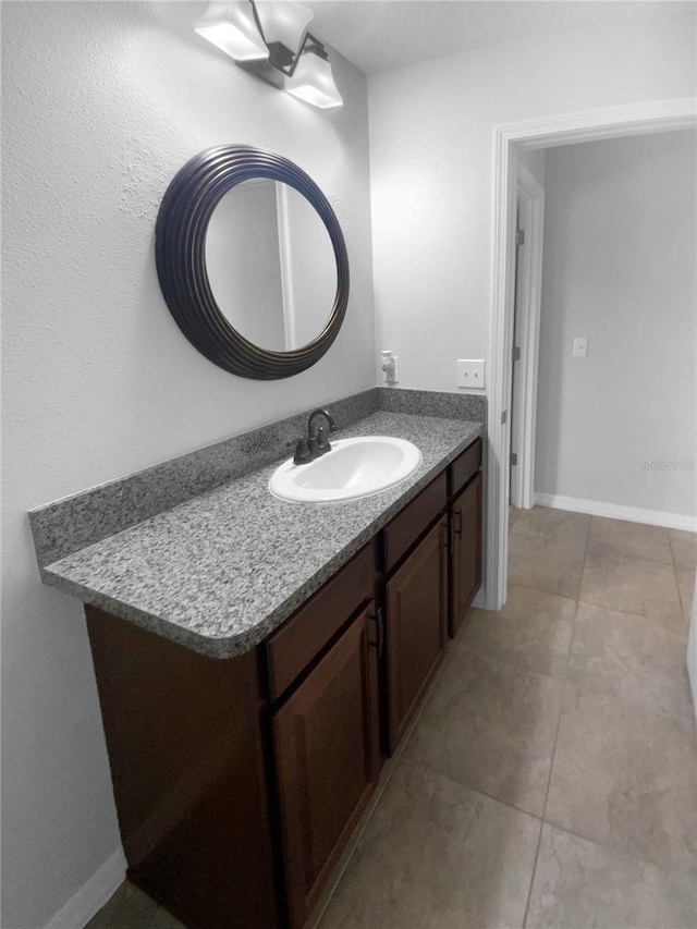 bathroom with tile patterned flooring, vanity, and baseboards