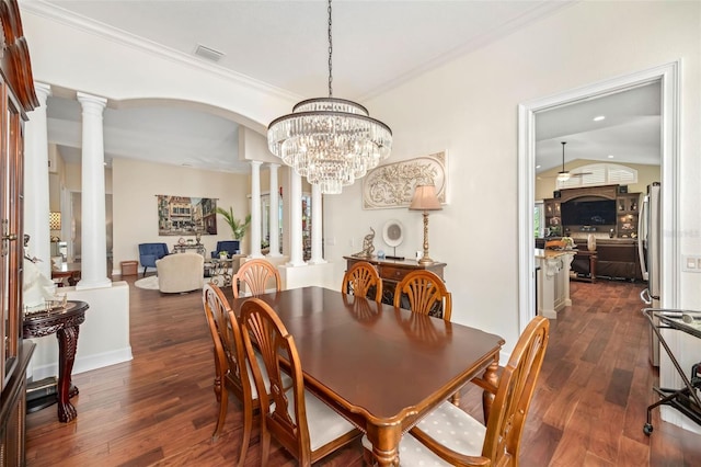 dining room featuring dark wood-style floors, visible vents, ornamental molding, and ornate columns