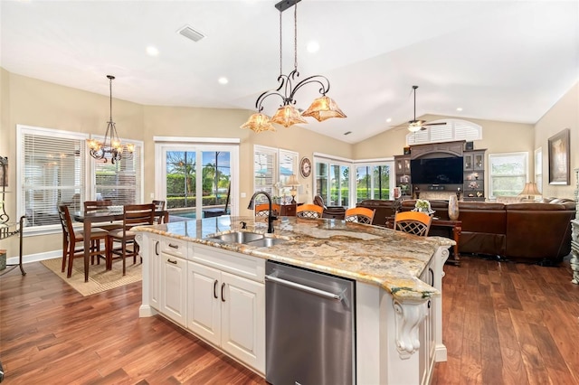 kitchen with a kitchen island with sink, visible vents, pendant lighting, and a sink