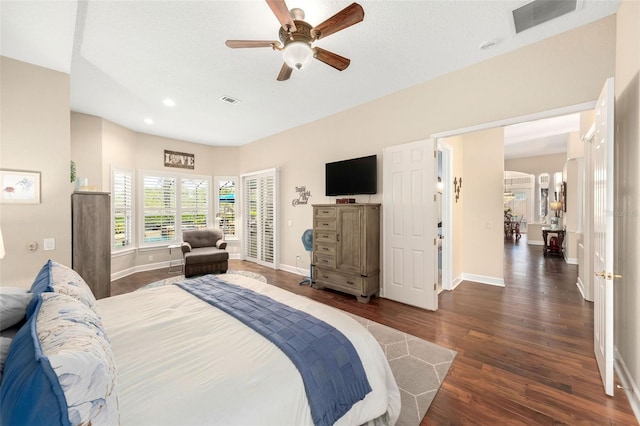 bedroom with visible vents, dark wood finished floors, and baseboards