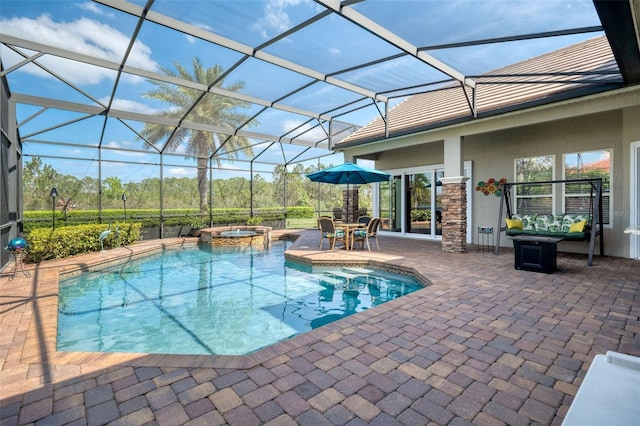 view of pool featuring a pool with connected hot tub, a lanai, and a patio