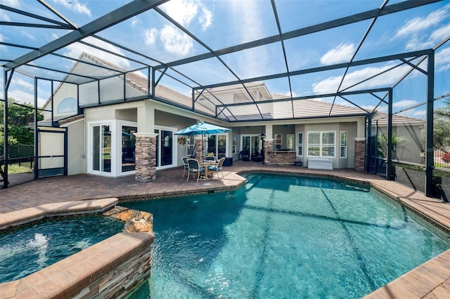 view of swimming pool with a pool with connected hot tub, a lanai, and a patio