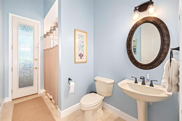 bathroom featuring toilet, tile patterned flooring, and baseboards