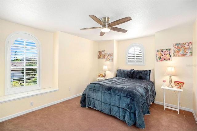 carpeted bedroom featuring a ceiling fan and baseboards