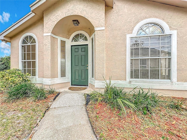 view of exterior entry featuring stucco siding