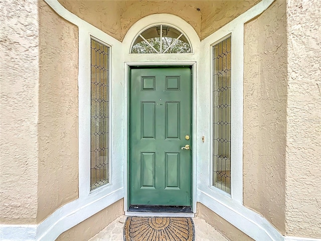 entrance to property featuring stucco siding