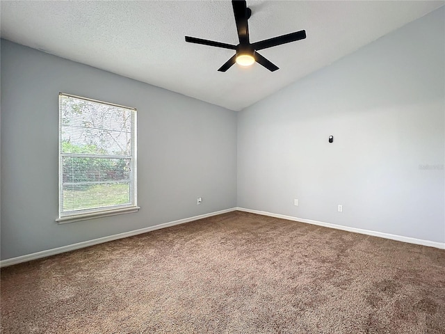 spare room featuring carpet, baseboards, vaulted ceiling, and a textured ceiling