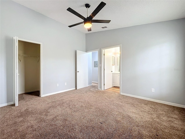 unfurnished bedroom with light carpet, baseboards, visible vents, lofted ceiling, and a textured ceiling