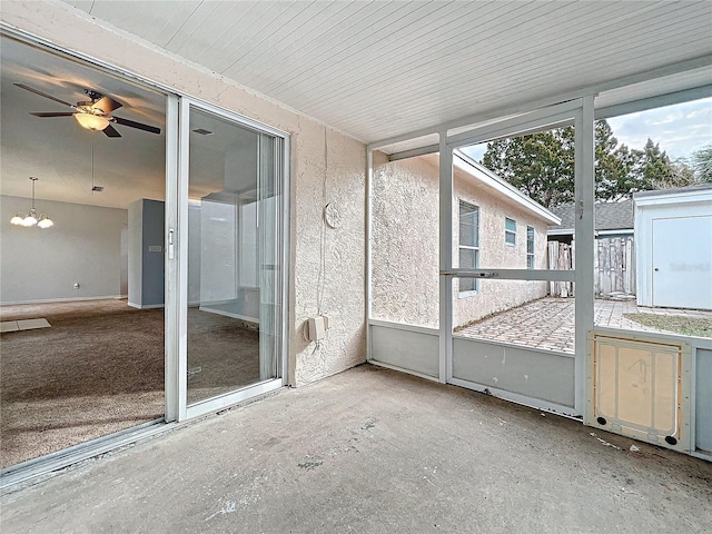 unfurnished sunroom with visible vents and ceiling fan with notable chandelier