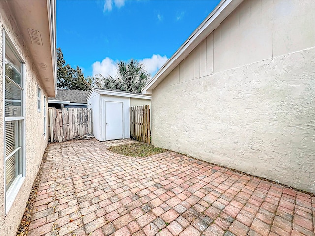 view of patio / terrace featuring a fenced backyard, an outdoor structure, and a shed