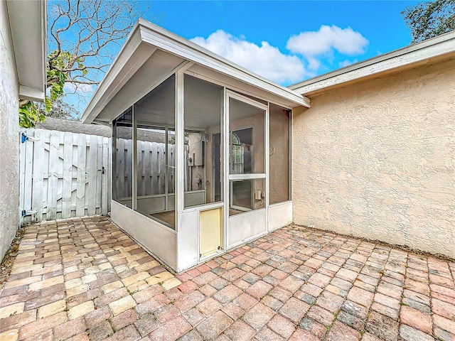 view of patio / terrace featuring a sunroom and fence