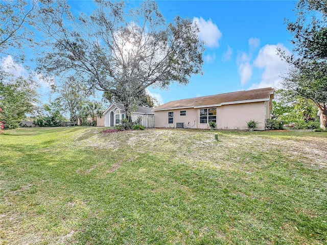 back of house with a lawn and stucco siding