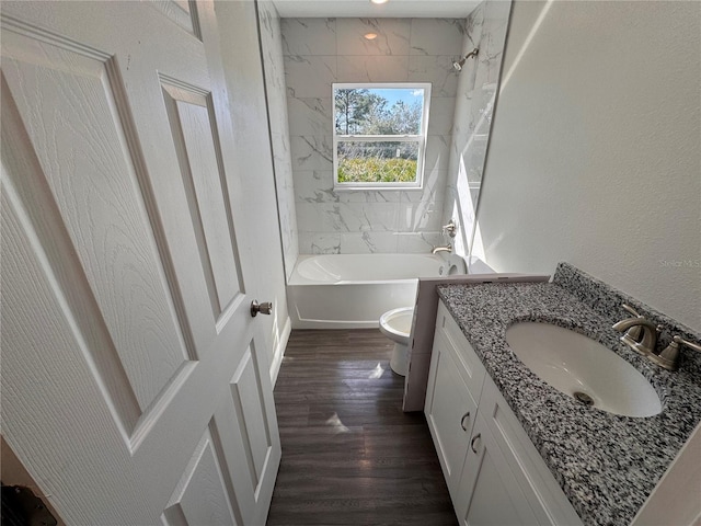 full bath featuring shower / washtub combination, a textured wall, toilet, vanity, and wood finished floors