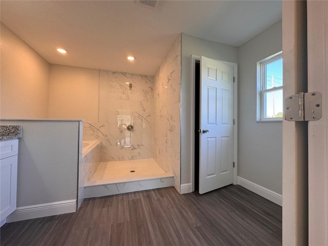 full bathroom featuring recessed lighting, baseboards, a marble finish shower, and wood finished floors