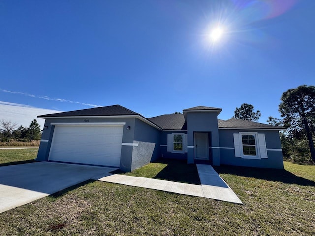 view of front of home with a garage, driveway, a front lawn, and stucco siding