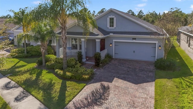 view of front of property with covered porch, decorative driveway, and a front yard