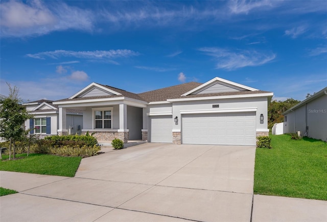 view of front of property featuring a garage, concrete driveway, stone siding, stucco siding, and a front yard