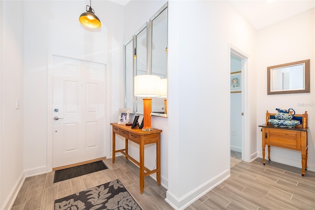 foyer entrance with wood tiled floor and baseboards