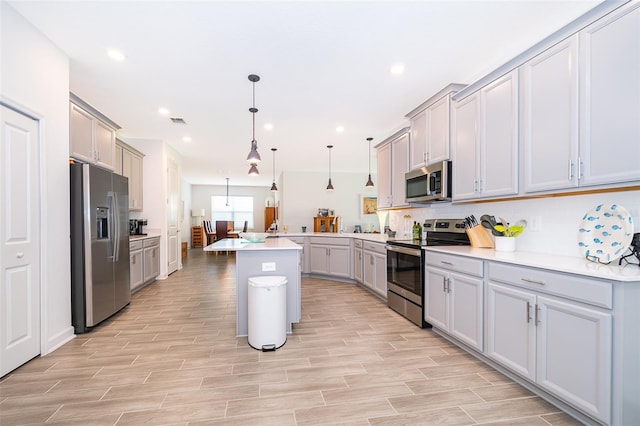 kitchen with stainless steel appliances, tasteful backsplash, gray cabinets, and visible vents