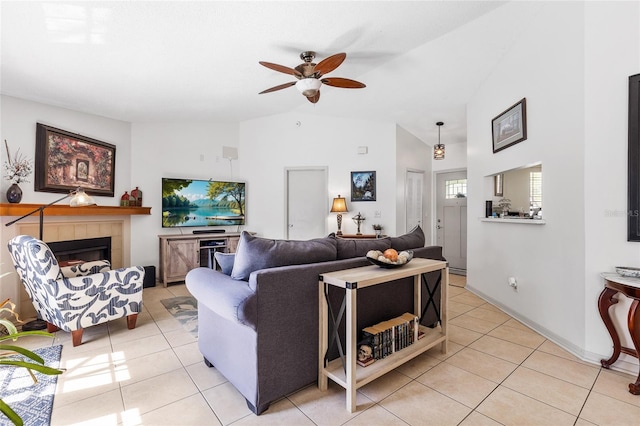 living room with light tile patterned floors, ceiling fan, a tiled fireplace, and high vaulted ceiling