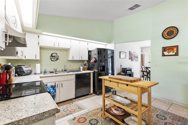 kitchen featuring a high ceiling, a sink, light tile patterned floors, black appliances, and visible vents
