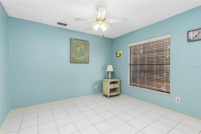 empty room featuring visible vents, ceiling fan, and baseboards