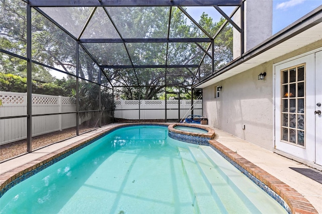 view of swimming pool with fence, glass enclosure, and a pool with connected hot tub