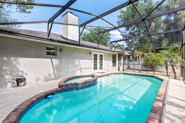 view of pool featuring fence, a patio, glass enclosure, a pool with connected hot tub, and french doors