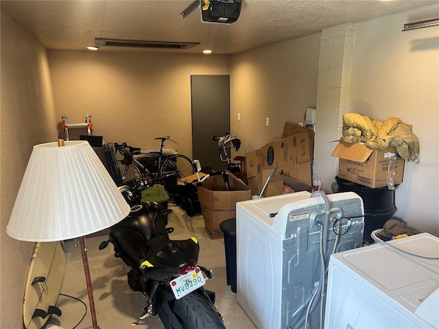 garage with a garage door opener and independent washer and dryer