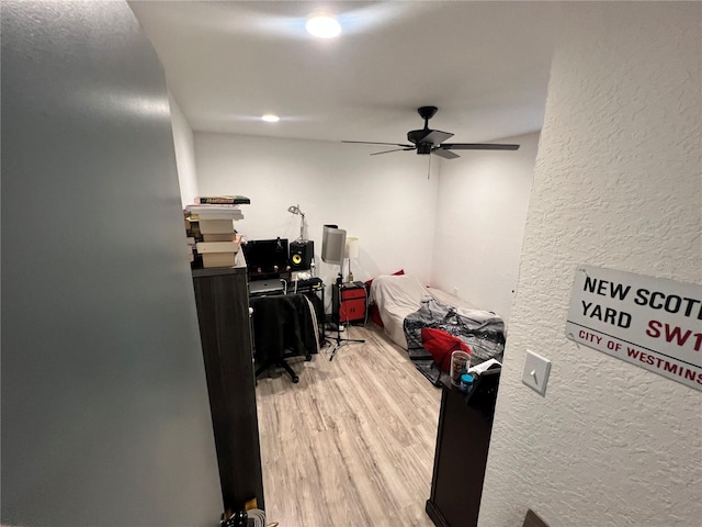 office space featuring ceiling fan, wood finished floors, and a textured wall